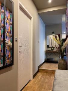 a hallway with a white door and a mirror at Grand Appartement Hyper Centre in Lens