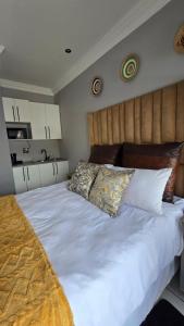 a bedroom with a large white bed with two pillows at HUZULA Royal Residence in Empangeni