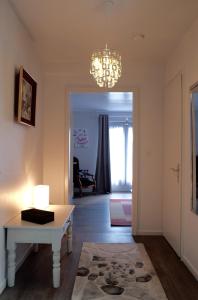 a living room with a table and a chandelier at Les Sources de Saverne in Saverne