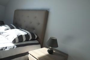 a bedroom with a bed and a lamp on a table at Les Sources de Saverne in Saverne