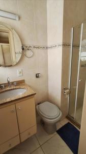 a bathroom with a toilet and a sink and a mirror at Recanto da Serra Imperial in Lambari