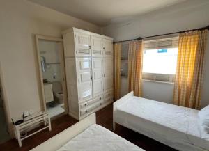 a small bedroom with two beds and a window at Recanto da Serra Imperial in Lambari