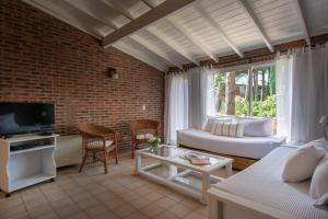 a living room with a couch and a tv at Carilo Village Apart Hotel & Spa in Carilo