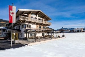 a building with a flag in the snow at Seefeldstub'n in Kirchberg in Tirol