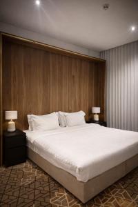 a bedroom with a large white bed with two lamps at LeChateau Boutique Hotel in Jeddah +36 photos