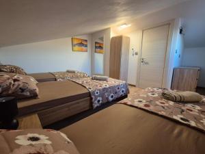 a bedroom with two beds and a door to a room at Apartman Meghan in Pula +18 photos