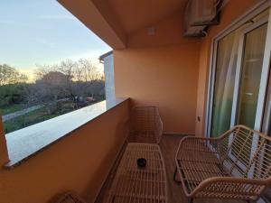 a balcony with two benches and a large window at Apartman Meghan in Pula