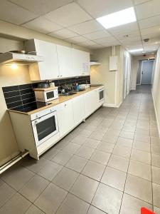 a large kitchen with white cabinets and appliances at Hotell Bromma in Stockholm