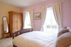 a bedroom with a bed and a large window at Ashmount Lodge in Ballynageragh