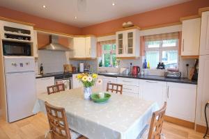 a kitchen with a table with a vase of flowers on it at Ashmount Lodge in Ballynageragh