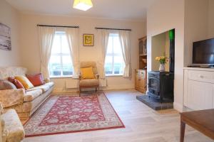 a living room with a couch and a stove at Ashmount Lodge in Ballynageragh