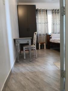 a room with a table and a chair and a bed at Mobi house Malindi in Malindi