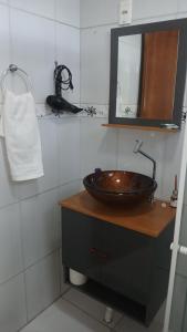 a bathroom with a sink and a mirror at Suíte 77 privativa , há 11km da vila germânica in Blumenau +8 photos
