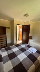 a bedroom with a checkered bed and a dresser at lo de Leo in Concordia