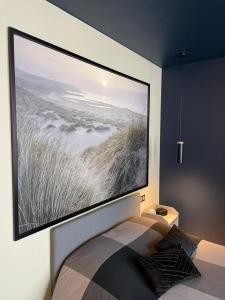 a large tv hanging on a wall above a bed at Studio Charmant Hyper Centre in Lens