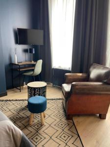 a living room with a couch and a chair and a desk at Studio Charmant Hyper Centre in Lens