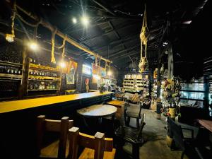 a bar with tables and chairs in a room at NYUNGWE ECOLODGE - Gisakura in Nyamasheke