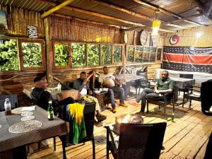 a group of men sitting in a restaurant at NYUNGWE ECOLODGE - Gisakura in Nyamasheke