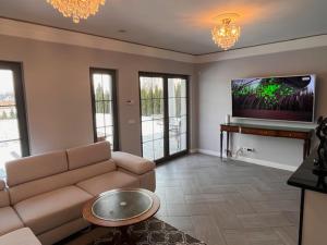 a living room with a couch and a flat screen tv at Dom Berry in Chrzanow