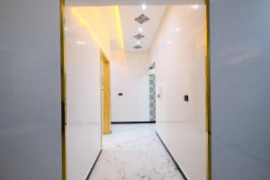 a hallway with white walls and a mirror at RiadRiad Bollywood-Dream Stay B in Benguerir