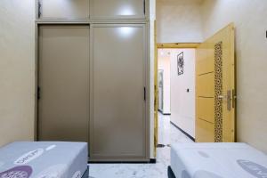 two beds in a room with a door at RiadRiad Bollywood-Dream Stay B in Benguerir