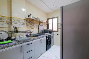 a kitchen with a sink and a washing machine at RiadRiad Bollywood-Dream Stay B in Benguerir