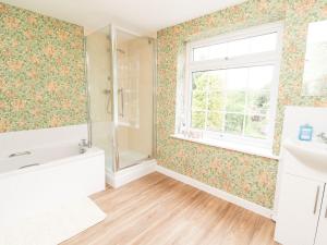 a bathroom with a tub and a sink and a window at Cae Adar Farm in Wrexham +33 photos