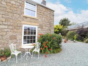 a table and chairs in front of a stone building at Cae Adar Farm in Wrexham