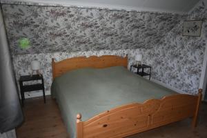 a bedroom with a wooden bed with floral wallpaper at Villa Frida in Kilen