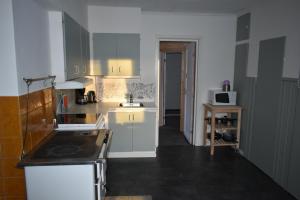 a kitchen with white cabinets and a black counter top at Villa Frida in Kilen