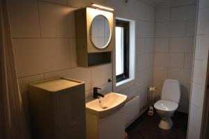 a bathroom with a sink and a mirror and a toilet at Villa Frida in Kilen +10 photos
