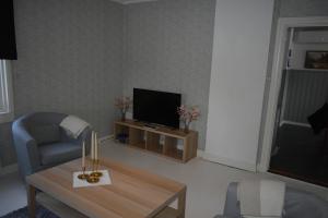 a living room with a table and a tv at Villa Frida in Kilen