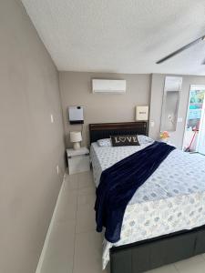 a bedroom with a bed with a blue comforter at Nice private room with separate entrance in Port Richey