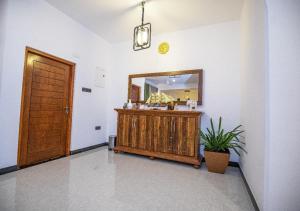 a bathroom with a vanity and a mirror and a door at Villa Freedom Hikkaduwa in Hikkaduwa +99 photos