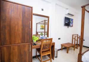 a dining room with a table and a wooden cabinet at Villa Freedom Hikkaduwa in Hikkaduwa
