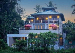 a large white house with a tower at Villa Freedom Hikkaduwa in Hikkaduwa