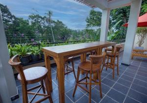 a porch with a wooden table and chairs on a balcony at Villa Freedom Hikkaduwa in Hikkaduwa