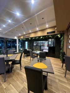 a restaurant with tables and chairs and plants at Oasi Urbana in Casoria