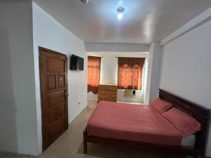a bedroom with a red bed and a door at Hotel luque in Guayaquil +7 photos