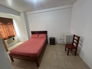 a bedroom with a red bed and a chair at Hotel luque in Guayaquil