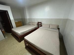 two beds in a small room with two beds at Hotel luque in Guayaquil