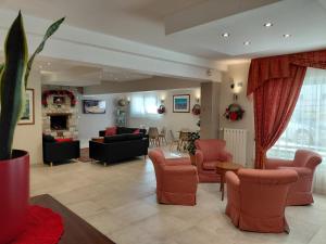 a living room with couches and chairs and a fireplace at Albergo Conte Max in Capracotta