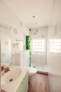 a white bathroom with a toilet and a sink at HOTEL RESTAURANT LA COTE REVEE in Leucate +137 photos