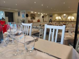 a restaurant with white tables and chairs with wine glasses at Albergo Conte Max in Capracotta