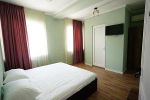 a bedroom with a bed and a window and a door at Hotel Maisis Ezo in Kutaisi +19 photos