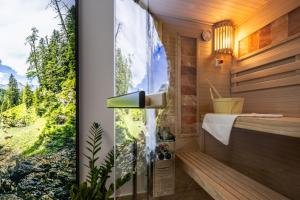 a bathroom with a shower with a view at ALPHAtauern Health Resort - Adults Only 15 plus in Obertauern
