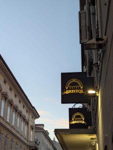 a couple of signs on the side of a building at Hotel Bristol in Trieste