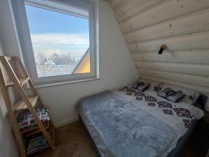a small bedroom with a bed and a window at Wierchy Resort 21B by AWapartaments in Zakopane
