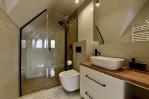 a bathroom with a toilet and a sink and a shower at Wierchy Resort 21B by AWapartaments in Zakopane +44 photos