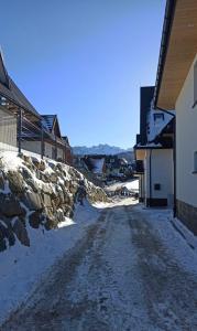 a dirt road with snow on the side of a building at Wierchy Resort 21B by AWapartaments in Zakopane